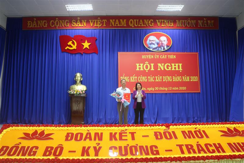 Đồng chí Nguyễn Thị Nhạn - Phó trưởng Ban Thường trực Ban Tổ chức Tỉnh ủy chúc mừng và trao quyết định nghỉ hưu đối với đồng chí Ngô Xuân Hiển (ảnh VT)
